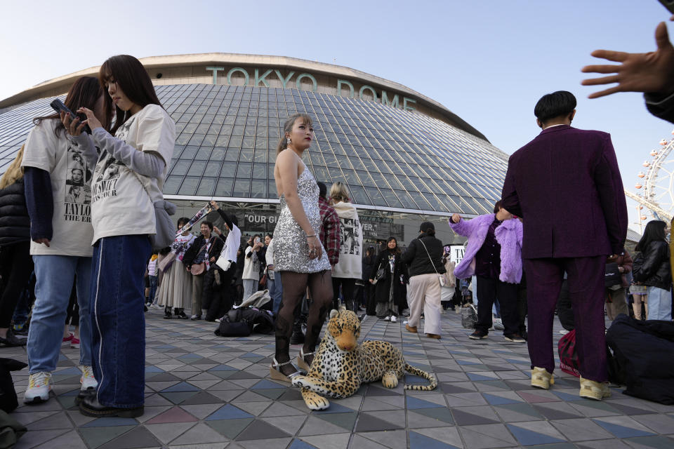 A woman poses for a photo with a stuffed animal of a leopard before Taylor Swift's concert at Tokyo Dome in Tokyo, Saturday, Feb. 10, 2024. The Swift's fan said a leopard is a character that appears in Swift's song. (AP Photo/Hiro Komae)