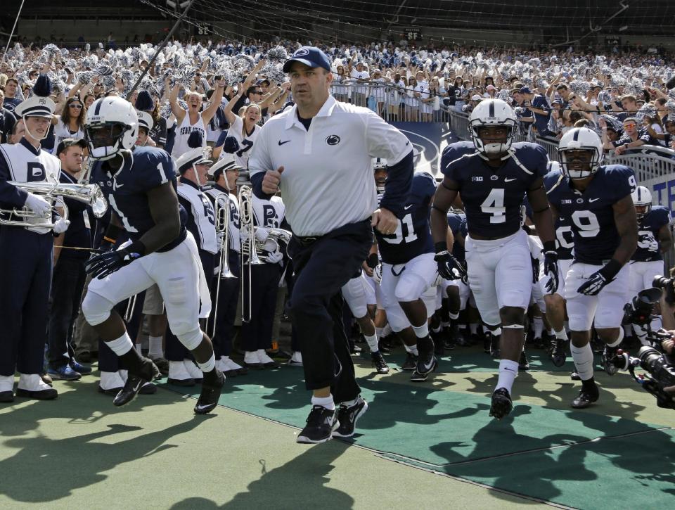 In this Sept. 7, 2013, photo, Penn State coach Bill O' Brien leads his team onto the field at Beaver Stadium for an NCAA college football game against Eastern Michigan in State College, Pa. Two people familiar with the negotiations say O'Brien has reached an agreement to coach the Houston Texans. The people spoke to The Associated Press on the condition of anonymity because an official announcement hasn't been made. (AP Photo/Gene J. Puskar)
