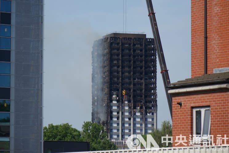 圖為倫敦24層公寓大樓「格蘭菲塔」（Grenfell Tower），大火後頂端樓層被燒得只剩下骨架。(中央社)