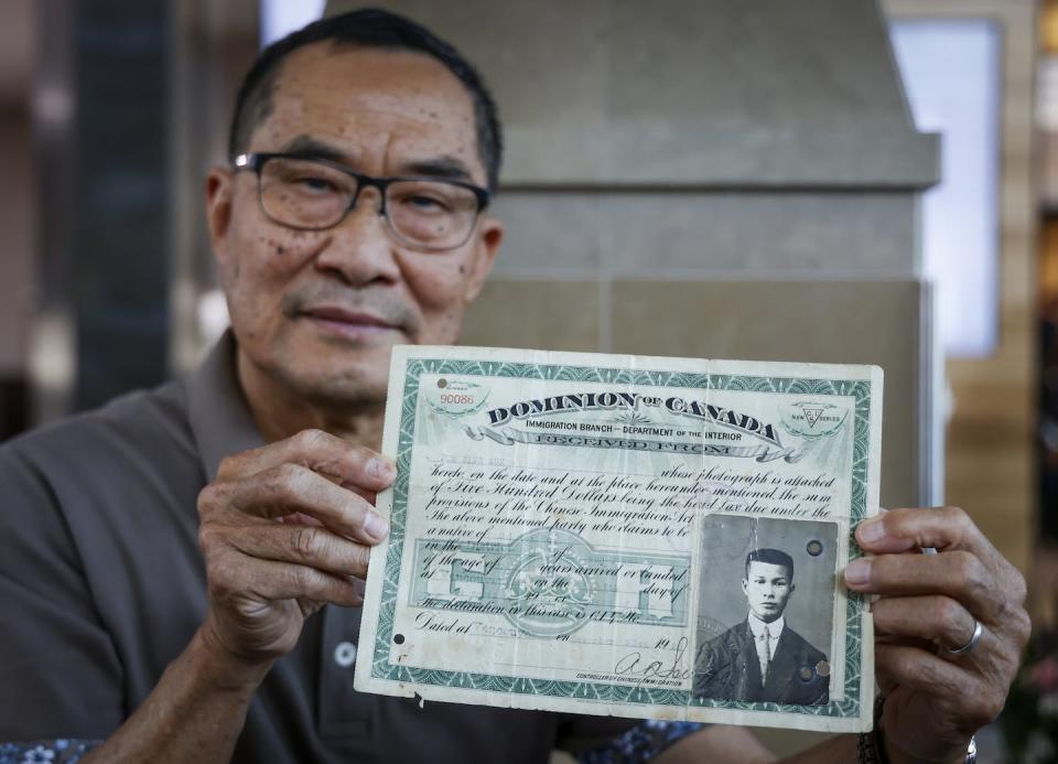 Matthew Yan, whose father paid a $500 head tax to enter Canada in 1920, holds his father’s identification certificate. THE CANADIAN PRESS/Jeff McIntosh