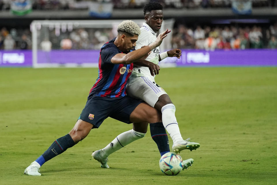 FILE - Barcelona's Araujo, left, and Real Madrid's Vinicius Jr. battle for the ball during the first half of a friendly soccer match in Las Vegas, Saturday, July 23, 2022. Vinicius Junior will get another shot at trying to get past Barcelona defender Ronald Araújo on Sunday, March 19, 2023, in a ''clasico'' match that will impact the Spanish league title race. (AP Photo/John Locher, File)