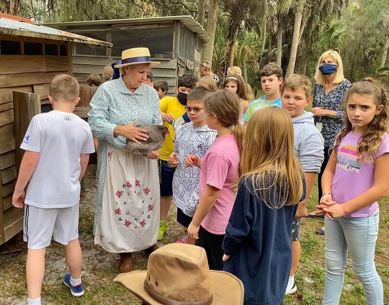 Schoolchildren meet chickens at the Crowley Museum and Nature Center. The museum's property recently became protected under a conservation easement.