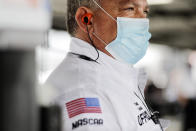 A NASCAR official wears a face mask because of the coronavirus pandemic as he works inside the garage before the NASCAR Xfinity series auto race Tuesday, May 19, 2020, in Darlington, S.C. NASCAR has developed a health plan approved by officials in both South Carolina and North Carolina and scheduled seven races over 11 days at two tracks. (AP Photo/Brynn Anderson)