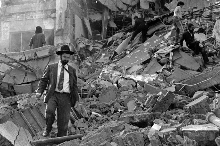 Un homme marche dans les décombres après l'attentat le 18 juillet 1994 contre la Mutuelle israélienne argentine (AMIA) à Buenos Aires (Ali Burafi)