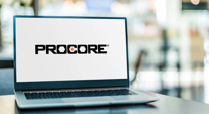 A laptop displays the logo for Procore Technologies (PCOR).