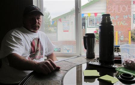 Larry Wood sits in the Butt's Tobacco store that he owns with his wife Jean in a strip mall south of Seattle, July 24, 2013. REUTERS/Andy Sullivan