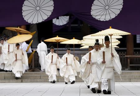 Shinto priests holding traditional umbrellas leave from the main shrine after a ritual to cleanse themselves during annual Spring Festival at the Yasukuni Shrine in Tokyo, Japan, April 21, 2016. REUTERS/Issei Kato