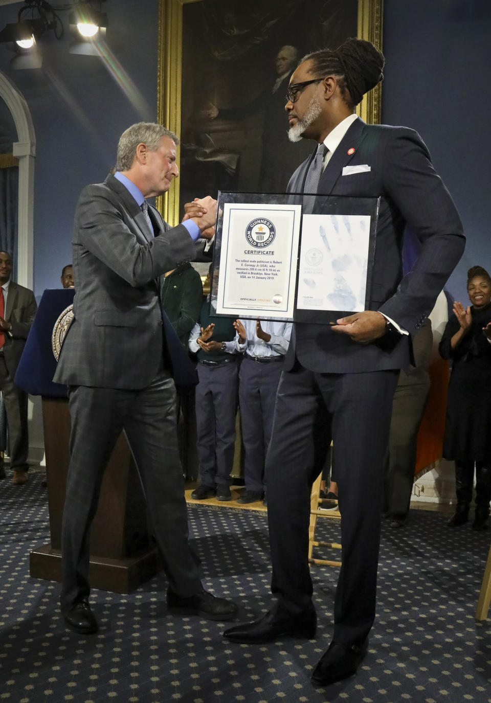 New York Mayor Bill de Blasio, left, awards N.Y. City Councilman Robert Cornegy, Jr. the Guinness World Record's tallest male politician, Wednesday March 27, 2019, at City Hall in New York. (AP Photo/Bebeto Matthews)