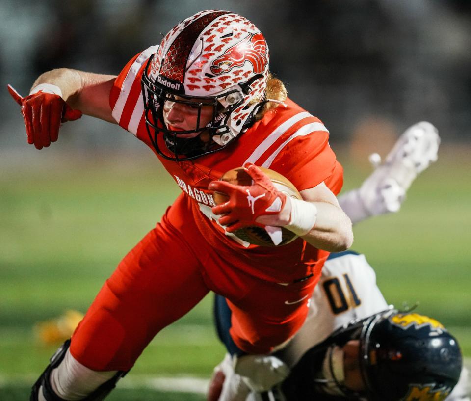 New Palestine Dragons Grayson Thomas (4) is tackled by Mooresville Pioneers Tyler Rakestraw (10) during the IHSAA Class 4A Regional Championship game between Mooresville Pioneers and New Palestine Dragons Friday, Nov. 10, 2023, at New Palestine High School in New Palestine. Dragons defeated Pioneers 39-6.