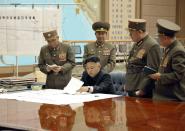 <p>North Korean leader Kim Jong-un presides over an urgent operation meeting on the Korean People’s Army Strategic Rocket Force’s performance of duty for firepower strike at the Supreme Command in Pyongyang, March 29, 2013. The sign on the left reads, “Strategic force’s plan to hit the mainland of the U.S.” (KCNA/Reuters) </p>