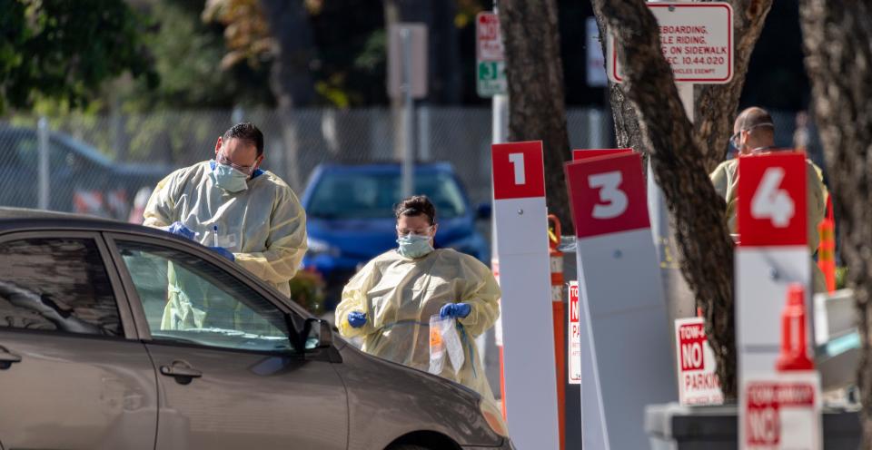 Kaweah Delta nurses collect nasal swabs for COVID-19 testing on Wednesday, April 1, 2020 at outdoor drive-up collection stations on Floral Street in Visalia, Calif. Appointments are required.