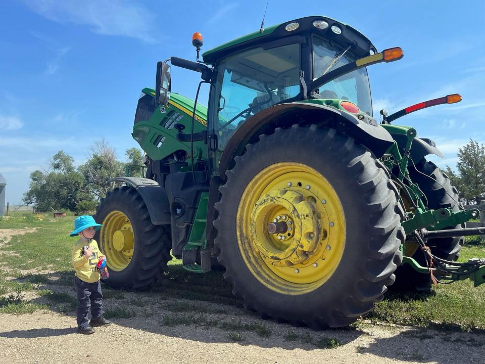 Two-year-old Solanus Zilverberg holds his toy tractor while standing in front of his dad's John Deere at the Bar JZ North Ranch in Holabird on July 24.