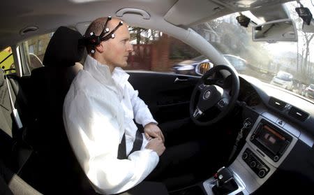 Daniel Goehring, of the AutoNOMOS research team of the Artificial Intelligence Group at the Freie Universitaet (Free University), demonstrates hands-free driving of the research car named 'MadeInGermany' during a test in Berlin, Germany February 28, 2011. REUTERS/Fabrizio Bensch/File Photo