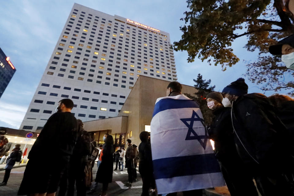 People gather in front of the "Westin Hotel" in Leipzig, Germany, Tuesday, Oct. 5, 2021 to show solidarity with the musician Gil Ofarim. A leading Jewish group in Germany says it's shocked by a German-Israeli singer’s report of being turned away from a hotel because he was wearing a Star of David pendant. Singer Gil Ofarim, who lives in Germany, shared a video on Instagram Tuesday showing him in front of the Westin hotel in Leipzig and saying a hotel employee asked him to put away his necklace in order to check in. (Dirk Knofe/dpa via AP)