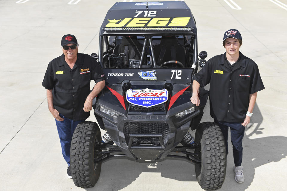 This March 9, 2019, photo provided by Auto Imagery shows former drag racer Don Prudhomme, left, and Jagger Jones at the Snake Racing Performance Shop in Vista, Calif. Prudhomme swore he would never enter the Mexican 1000 again after struggling to get through the difficult off-road race in Baja California. A year later, The Snake is tackling it again, this time with 16-year-old Jagger Jones at his side.(Richard Shute/Auto Imagery via AP)