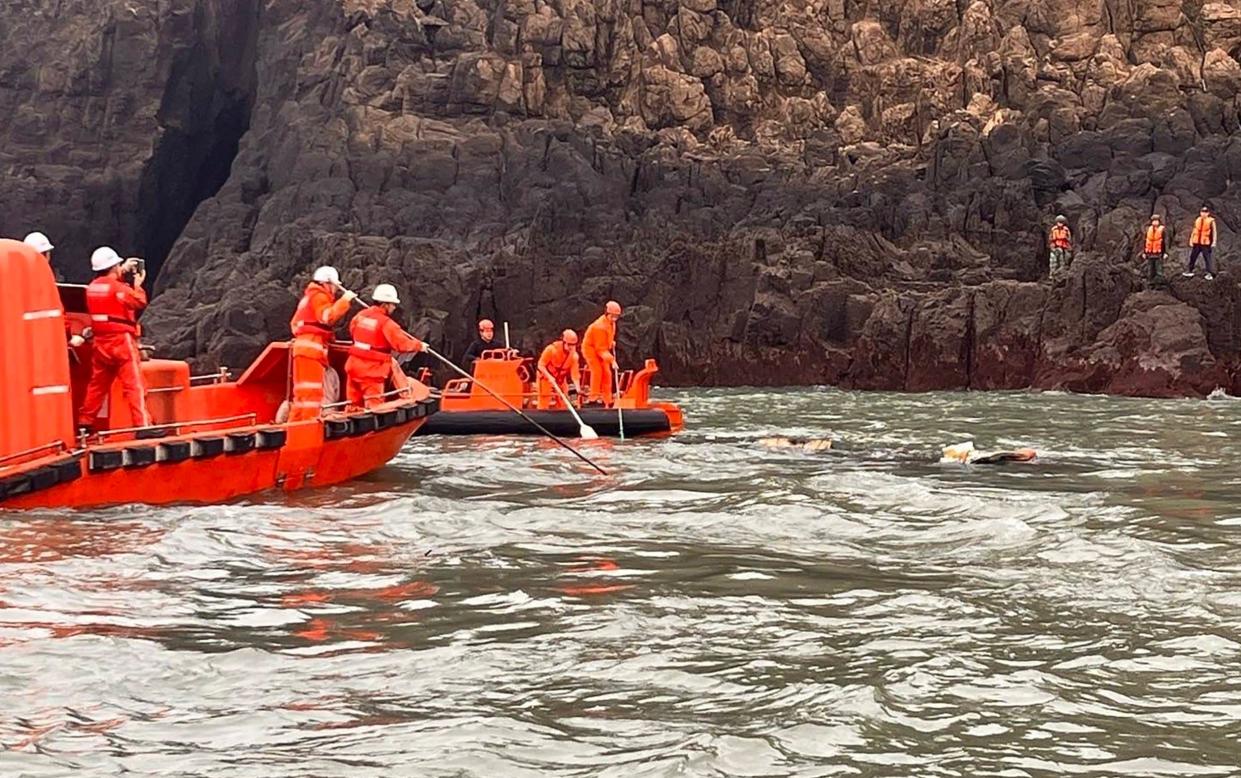 Chinese coastguard (white helmets) and Taiwan coastguard (orange helmets) in a joint search-and-rescue mission after a Chinese fishing boat capsized off the Kinmen Islands