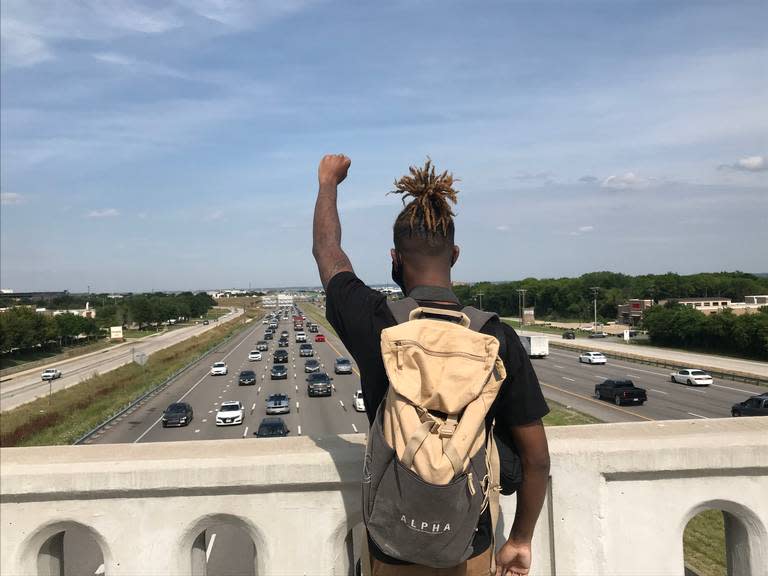 A protester raises a fist in the air on a bridge overlooking Interstate 20 in Arlington, Texas, on June 1, 2020.