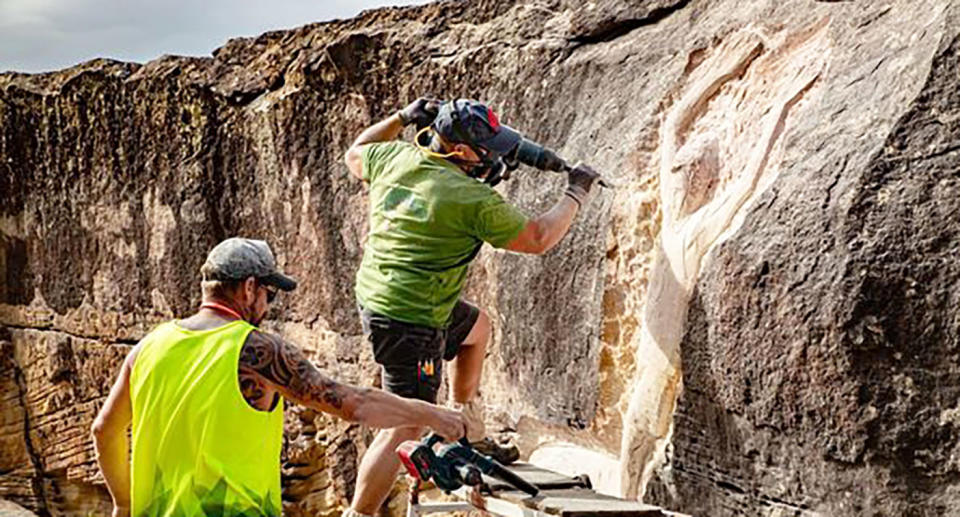 Seen here, Workers shape the contentious rock carving at Sydney's Palm Beach in tribute to surfing legend, Bernard 