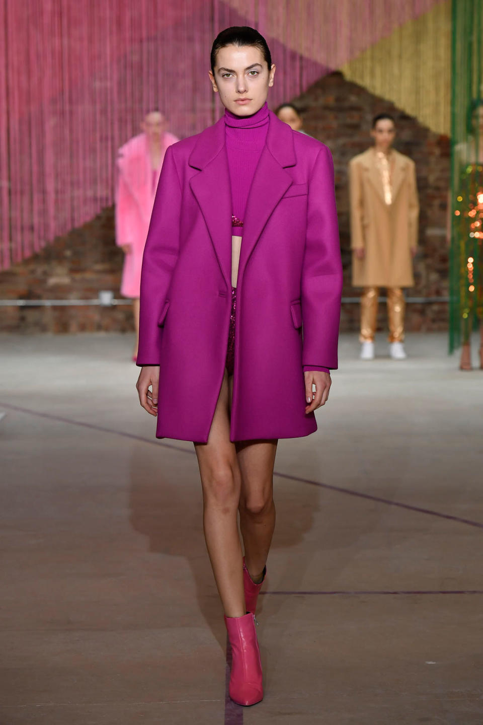 <p>Model wears a fuchsia coat, crop top, skirt, and booties at the Milly Fall/Winter 2018 show. (Photo: Courtesy of Greg Kessler) </p>