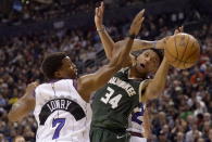 Toronto Raptors guard Kyle Lowry (7) and Milwaukee Bucks forward Giannis Antetokounmpo (34) vie for a loose ball during the first half of an NBA basketball game Tuesday, Feb. 25, 2020, in Toronto. (Nathan Denette/The Canadian Press via AP)