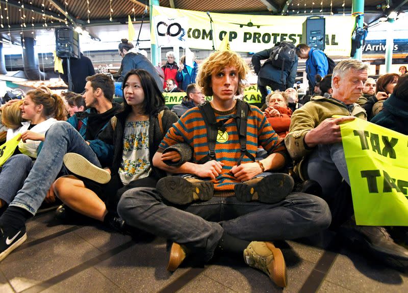 People demonstrate as Greenpeace stages a climate protest at Amsterdam Schiphol Airport in Schiphol