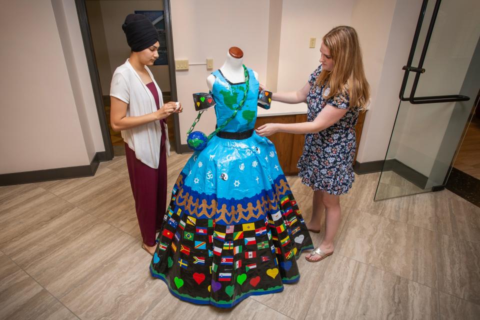 Ritika Singh works with Mount Mary University archivist Amanda Cacich to display Singh's duct tape dress, which she has donated to Mount Mary's fashion archive collection.