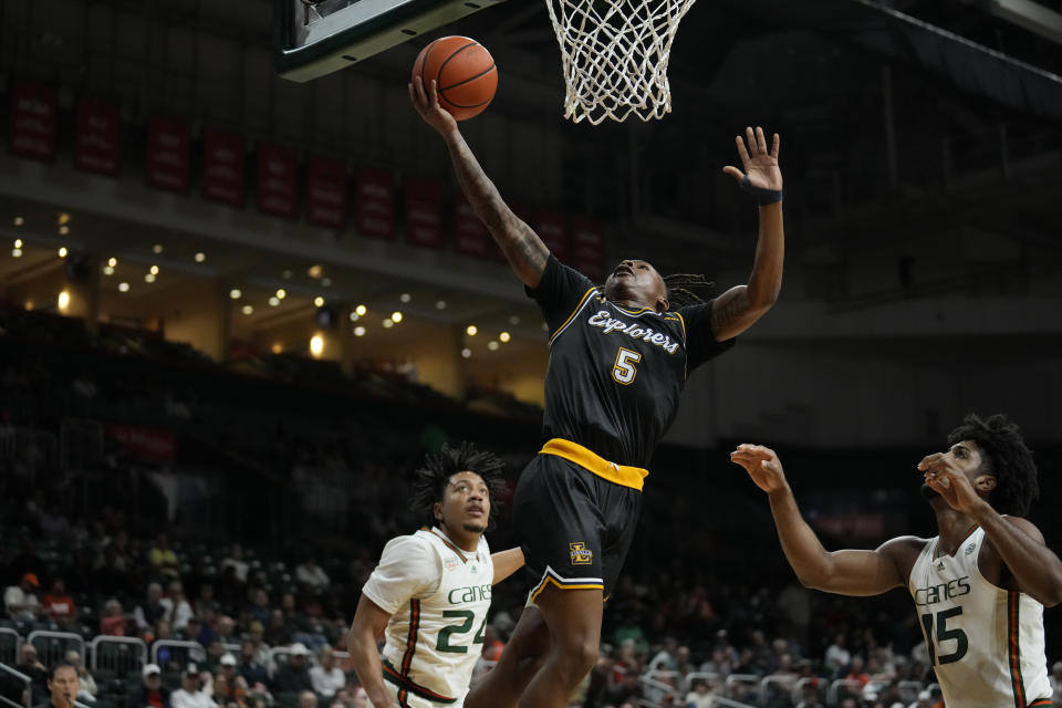 La Salle guard Khalil Brantley (5) jumps for the basket past Miami guard Nijel Pack (24) and Miami forward Norchad Omier (15) during the first half of an NCAA college basketball game, Saturday, Dec. 16, 2023, in Coral Gables, Fla. (AP Photo/Rebecca Blackwell)