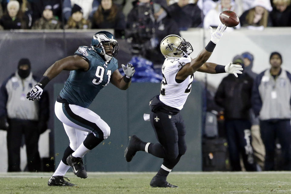 New Orleans Saints' Mark Ingram, right, cannot pull in a pass as Philadelphia Eagles' Fletcher Cox (91) pursues during the first half of an NFL wild-card playoff football game, Saturday, Jan. 4, 2014, in Philadelphia. (AP Photo/Julio Cortez)