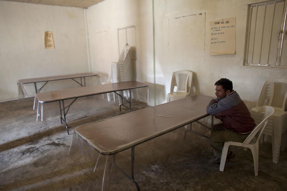 In this Feb. 11, 2014 photo, a man sits in a community kitchen dining area in Cochoapa El Grande, Mexico. The kitchen is supposed to open from Monday to Friday and provide free food for breakfast and lunch, but on this day no food was being prepared. (AP Photo/Dario Lopez-Mills)