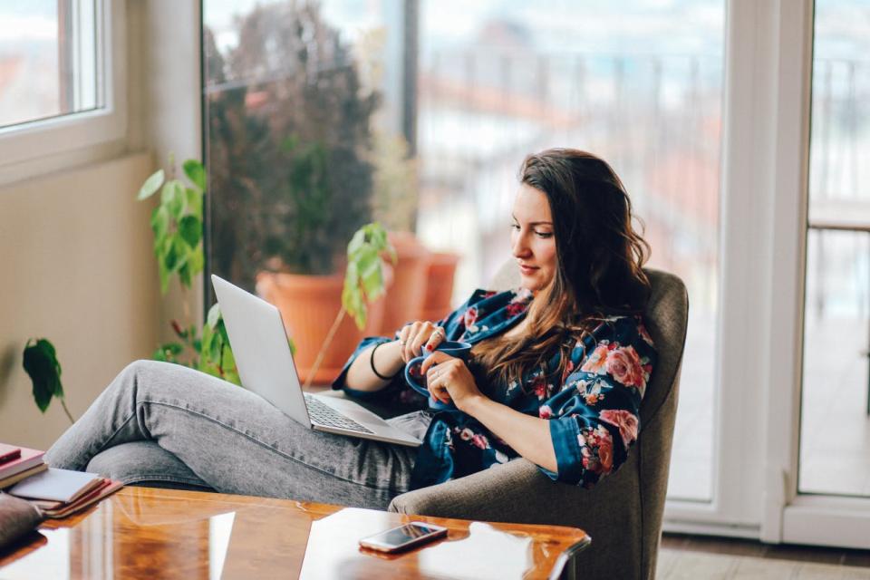 A woman uses a laptop in her living room