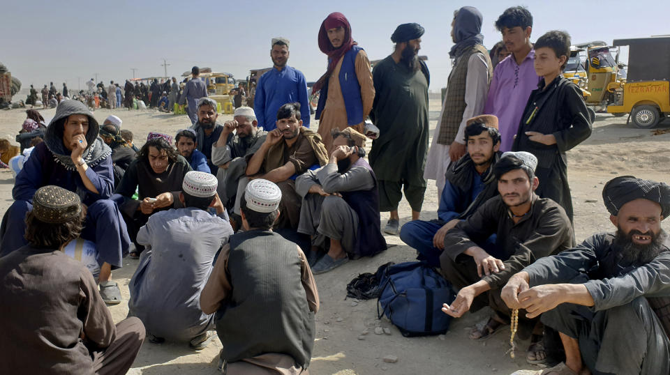 Stranded people gather and wait to open the border which was closed by authorities, in Chaman, Pakistan, Saturday, Aug. 7, 2021. Chaman border crossing is one of busiest border crossings between Pakistan and Afghanistan. Thousands of Afghans and Pakistanis cross daily and a steady stream of trucks passes through, taking goods to land-locked Afghanistan from the Arabian Sea port city of Karachi in Pakistan. (AP Photo/Tariq Achakzai)