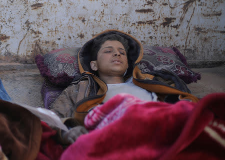 Hareth Najem, an Iraqi orphan lies under a blanket in a truck, near the village of Baghouz, Deir Al Zor province, Syria March 1, 2019. Picture taken March 1, 2019. REUTERS/Rodi Said