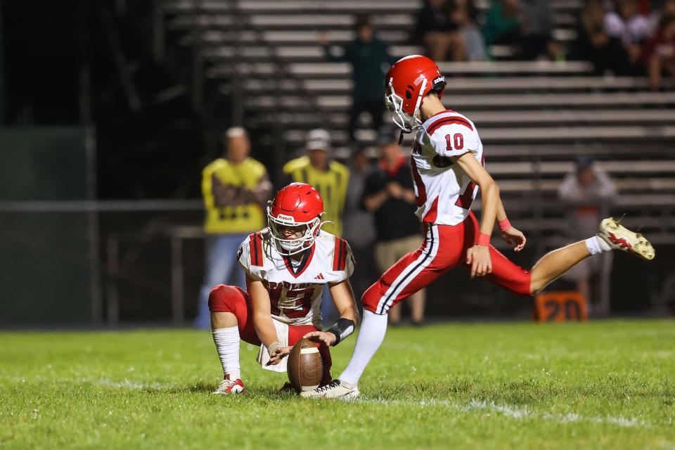 Spaulding's Nate Devine, as teammate Kaiden Melendez holds the ball, attempts a point-after kick Friday.