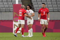 Madison Hughes, center, of the United States greets Britain's Tom Bowen, left, and Alex Davis after the U.S. team lost to Britain during their men's rugby sevens quarterfinal match at the 2020 Summer Olympics, Tuesday, July 27, 2021, in Tokyo. (AP Photo/Shuji Kajiyama)