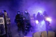 Policemen in riot gear in action during clashes with protestors in Barcelona, Spain, Tuesday, Oct. 15, 2019. Spain's Supreme Court on Monday convicted 12 former Catalan politicians and activists for their roles in a secession bid in 2017, a ruling that immediately inflamed independence supporters in the wealthy northeastern region. (AP Photo/Bernat Armangue)