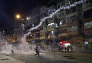 Protesters react to tear gas from Shum Shui Po police station in Hong Kong on Wednesday, Aug. 14, 2019. German Chancellor Angela Merkel is calling for a peaceful solution to the unrest in Hong Kong amid fears China could use force to quell pro-democracy protests.(AP Photo/Vincent Yu)