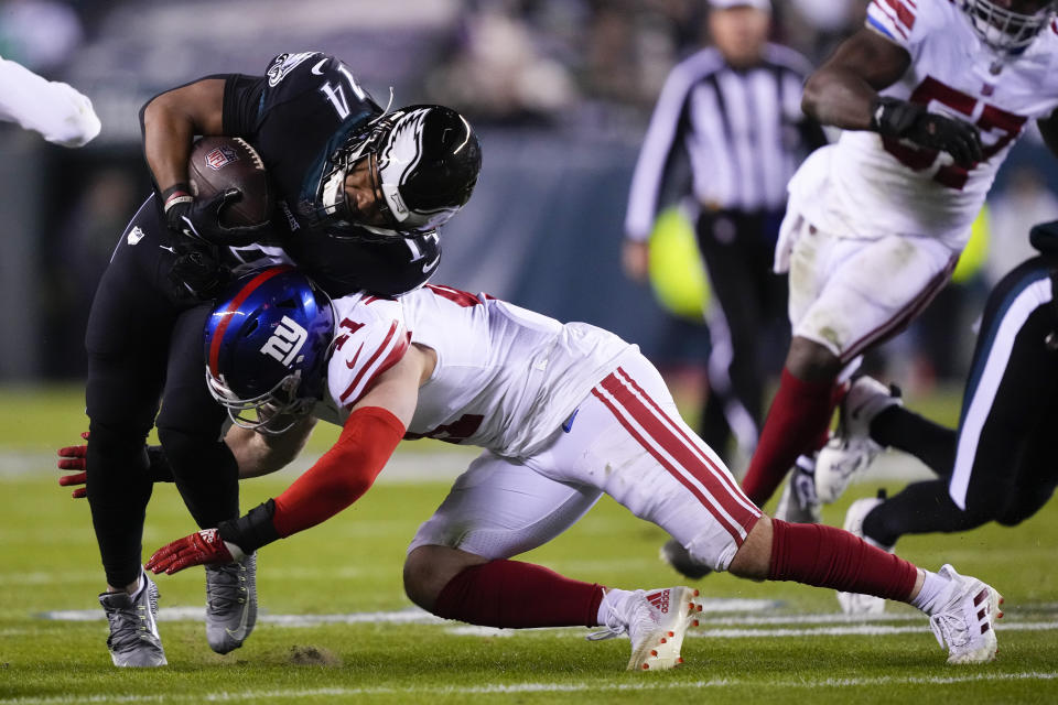 Philadelphia Eagles running back Kenneth Gainwell (14) takes a hit from New York Giants linebacker Micah McFadden (41) while running with the ball during the second half of an NFL football game, Sunday, Jan. 8, 2023, in Philadelphia. (AP Photo/Matt Rourke)