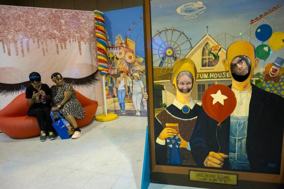 Jannet and George Beltran pose in the American Gothic cutout, on right, as Christine Turner and Shelly Martin, left, view selfies taken a sofa shaped like a pair of lips at the candy maze selfie experience at the California State Fair in Sacramento on Wednesday, July 17, 2024.