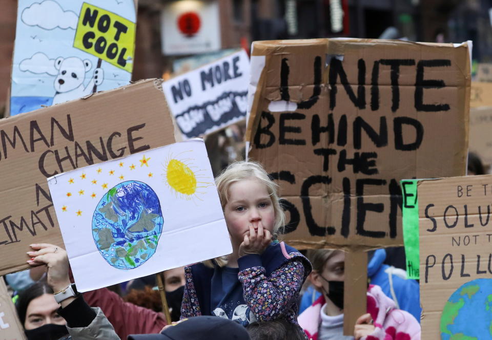 Demonstrators carry placards at a Fridays for Future climate change march during the UN Climate Change Conference (COP26), in Glasgow, Scotland, Britain, November 5, 2021. REUTERS/Russell Cheyne