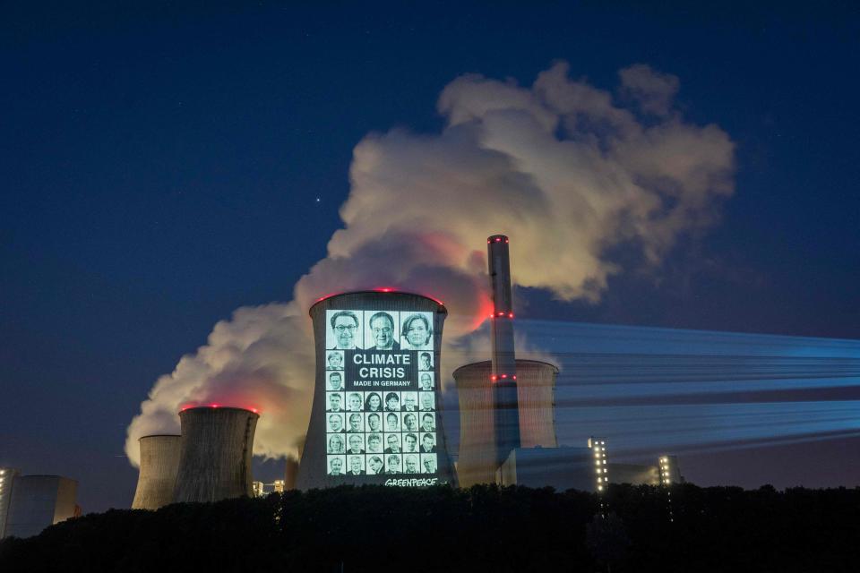 July 23, 2021: Portraits of 31 German politicians are projected with the slogan "Climate crisis, made in Germany" onto a cooling tower of the brown coal power station Neurath in Grevenbroich, Germany.