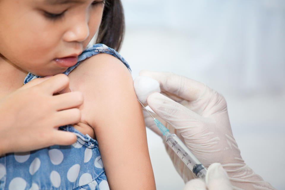 Doctor injecting vaccination in arm of asian little child girl,healthy and medical concept