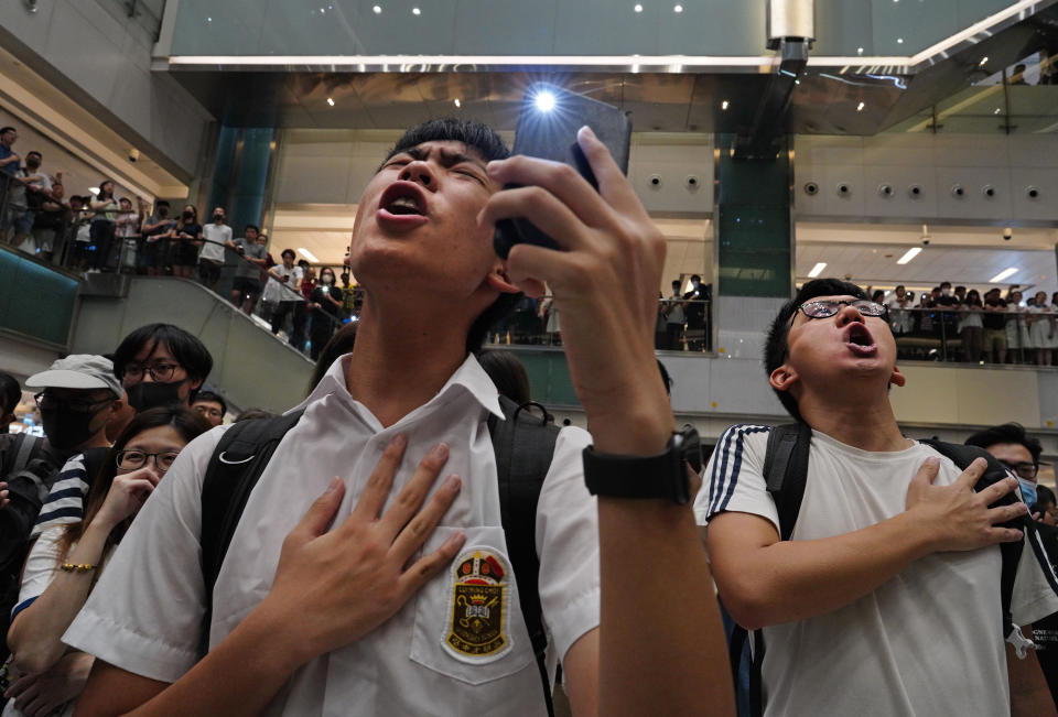 FILE - In this Sept. 11, 2019, file photo, local residents sing a theme song written by protesters "Glory be to thee" at a shopping mall in Hong Kong. With Britain the latest country to scrap an extradition treaty with Hong Kong, the focus has returned to concerns over Chinese justice that sparked months of anti-government protests in the semi-autonomous city last year. (AP Photo/Vincent Yu, File)