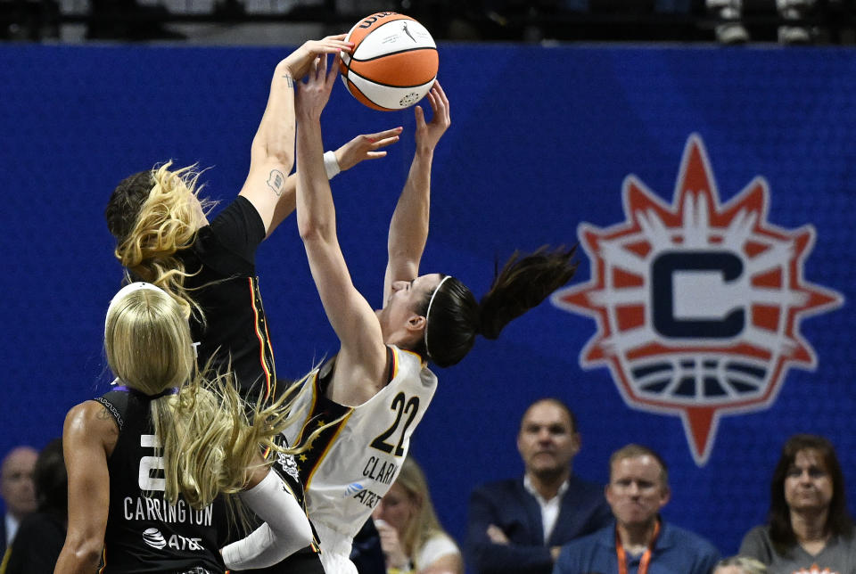 Connecticut Sun guard Rachel Banham (1) blocks a shot attempt by Indiana Fever guard Caitlin Clark (22) during the second quarter of a WNBA basketball game, Tuesday, May 14, 2024, in Uncasville, Conn. (AP Photo/Jessica Hill)