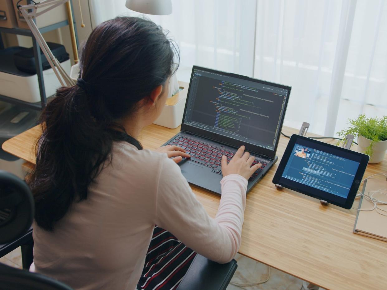 software developer coding on computer at desk at home