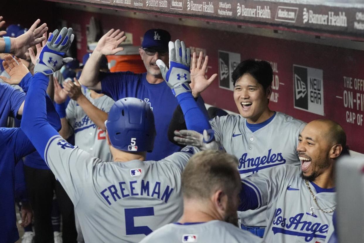 Freddie Freeman celebrates with teammates after hitting the Dodgers' third straight home run.