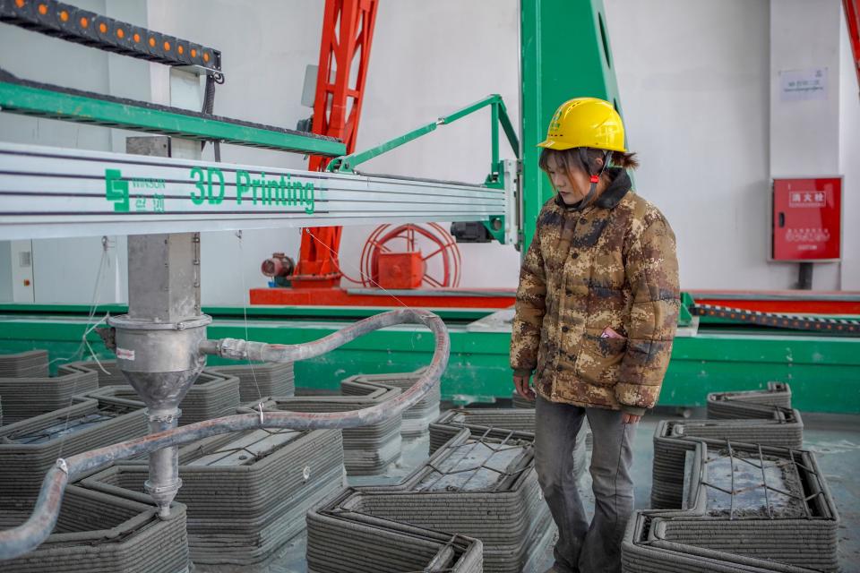 A worker checks the quality of 3D printing products at a construction company in Tsal Village, Tselgungthang Subdistrict of Lhasa, southwest China's Xizang Autonomous Region, Dec. 12, 2023. TO GO WITH 