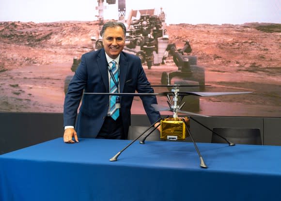 Man standing behind table with Mars Helicopter drone sitting on it