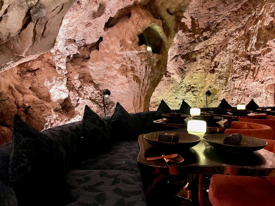 Inside a restaurant that's housed in a cave in Bali, Indonesia. The seats in the restaurant are arranged along the curve of the cave.