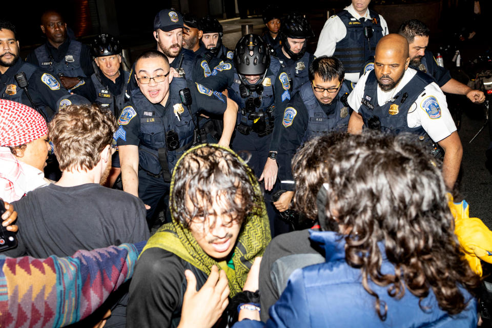 Demonstrators clash with the officers from the Metropolitan Police Department at George Washington University in Washington, early Wednesday, May 8, 2024. Police cleared a pro-Palestinian tent encampment at the university and arrested demonstrators early Wednesday, hours after dozens marched to the home of the school’s president. (Sage Russell/GW Hatchet via AP)