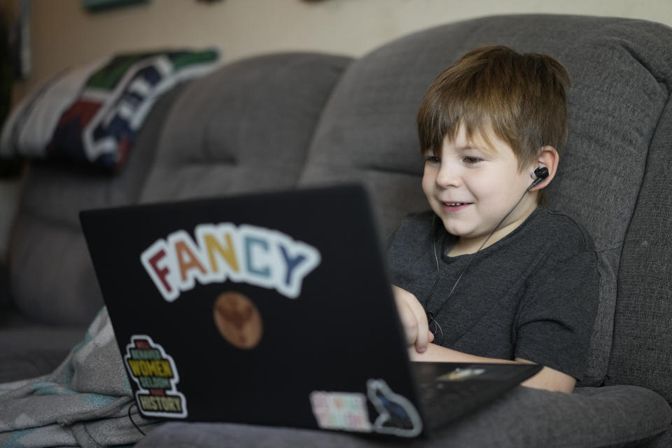 Phoenix Blalack, 6 , works with a tutor on his laptop in his Indianapolis home, Tuesday, March 7, 2023. (AP Photo/AJ Mast)